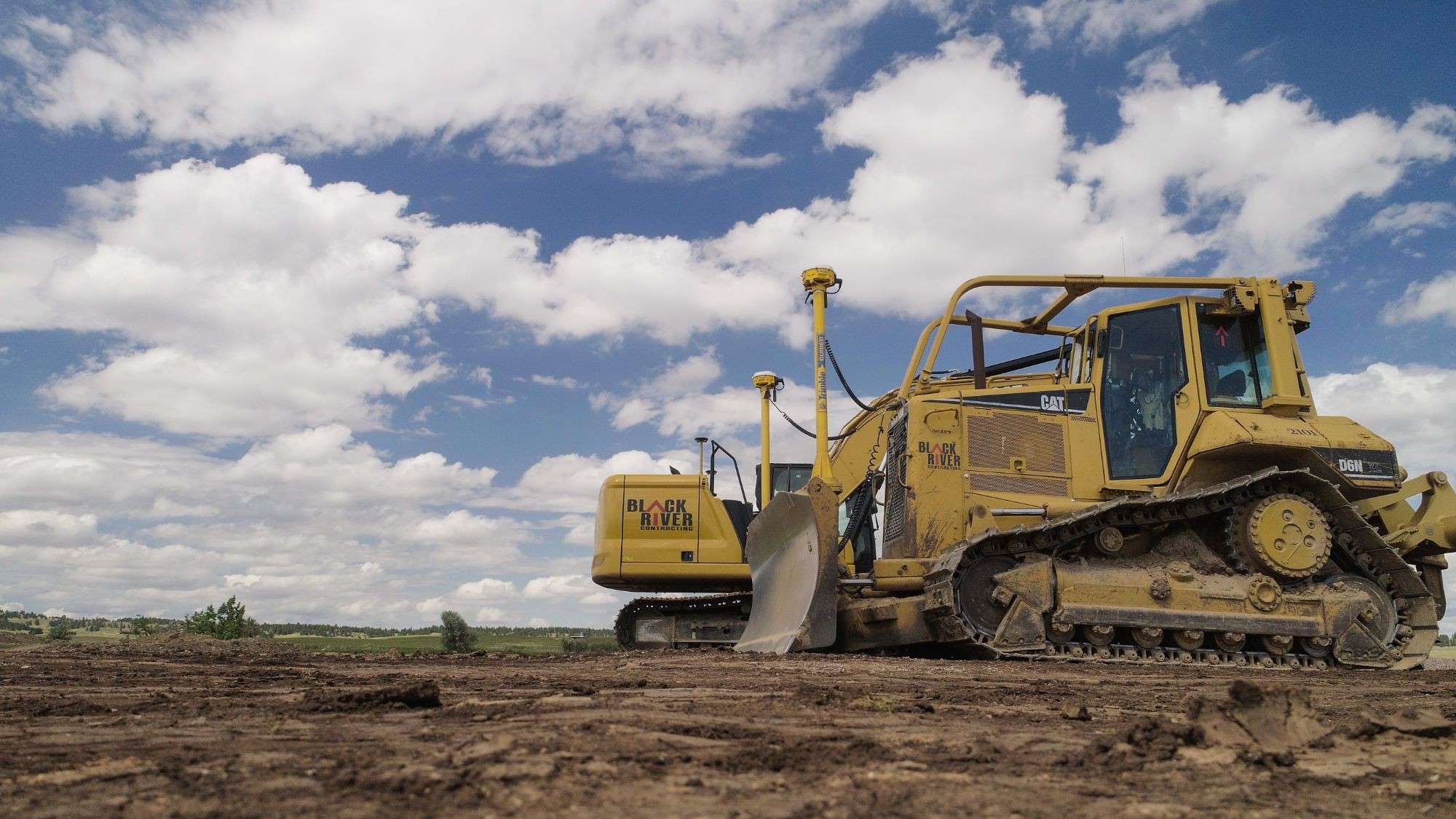 Black River Cat D6N dozer and excavator, both fitted with GPS grade control antennas, on a graded site